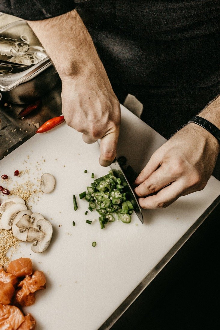 A chef chopping fresh herbs in the kitchen