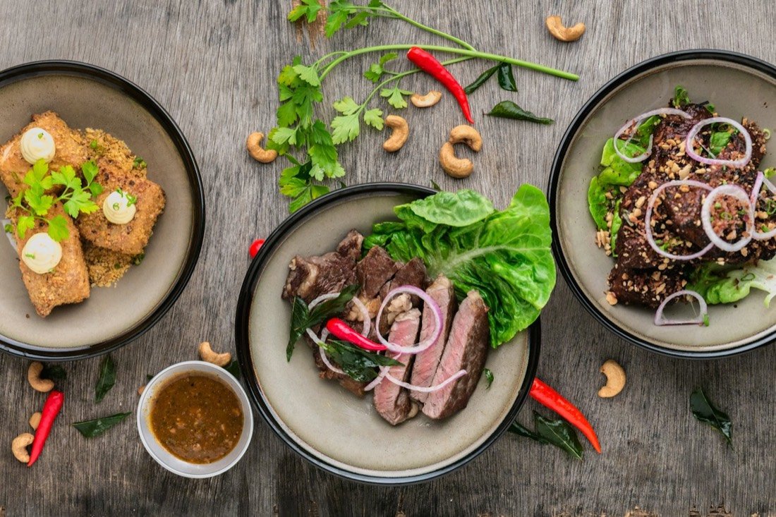 Shared plates of seared steak, salad and crispy tofu